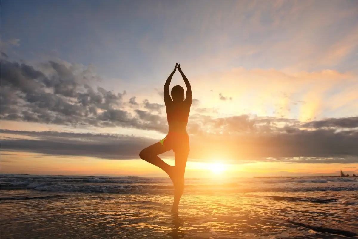 Koshas do Yoga - mulher praticando Yoga ao por do sol